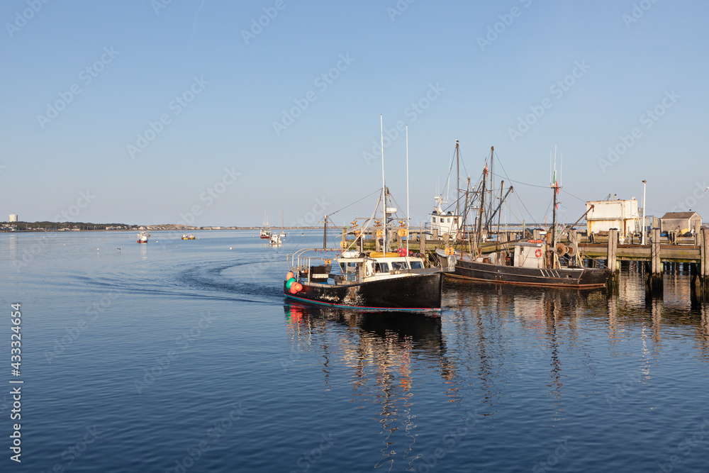 Fototapeta premium view to ships from Pier in Provincetown in sunset