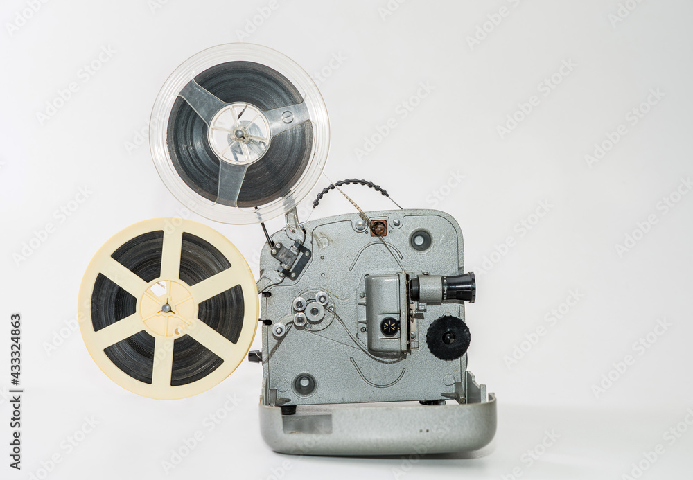 Naklejka premium Old vintage film projector for watching films on film strip on a white background.