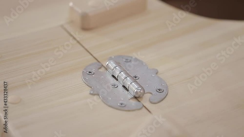 Close up wooden lid opens and metal door hinges with screws of cedar phytobarrel