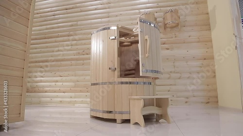 A half open cedar phyto-barrel with stool next to it in a room of the spa salon