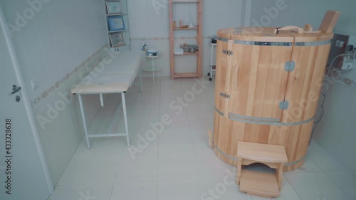 Spa room with cedar phytobarrel a stool is placed next to it, couch and a shelf