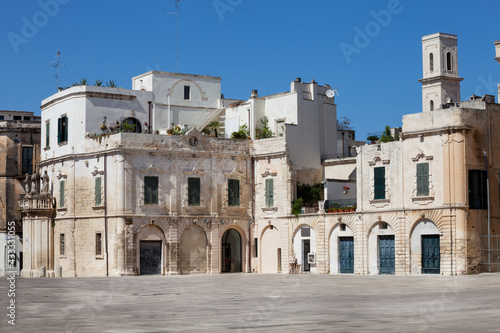 Old houses in the historic city of Lecce, Italy. White buildings in the square of the famous basilica Church of the Holy Cross (Santa Croce).
