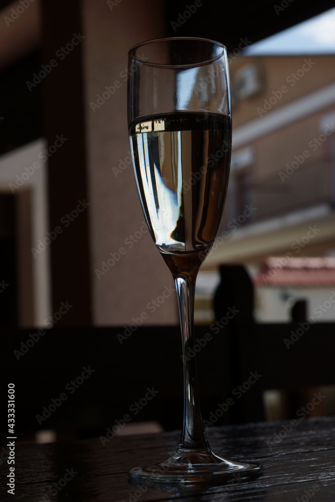 Glass of sparkling wine on a wooden table. Summer romantic evening.
