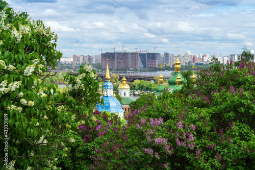 Panoramic view of the city of Kiev or Kyiv. The gilded domes of the cathedral among the blooming Syringa photo