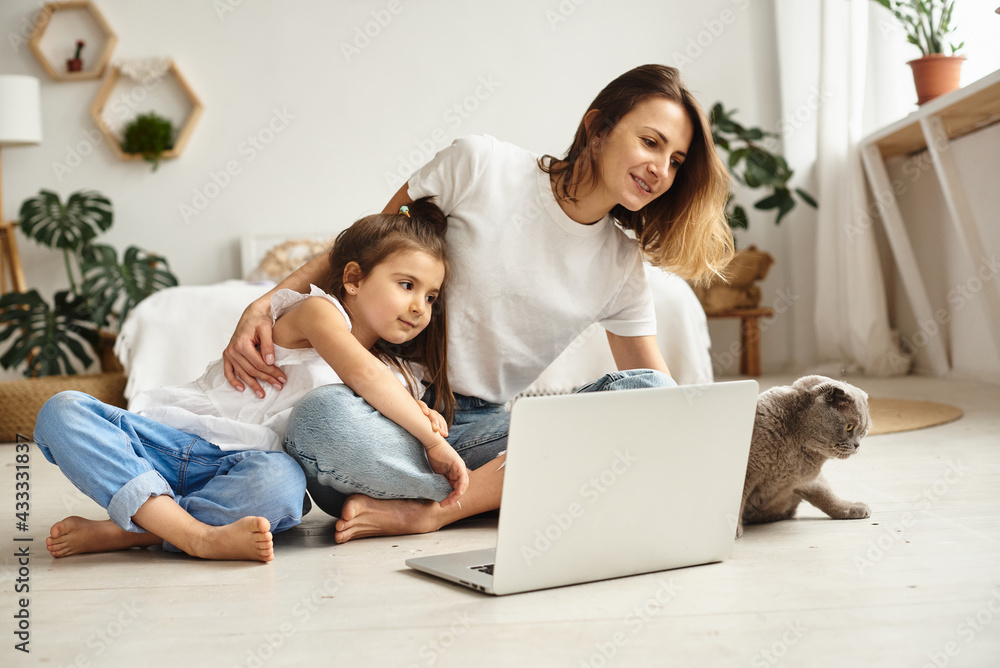daughter watching mom work on computer daughter watching mom work on computer