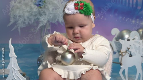 Slow Motion girl sitting on the floor and holding a Christmas ball  photo