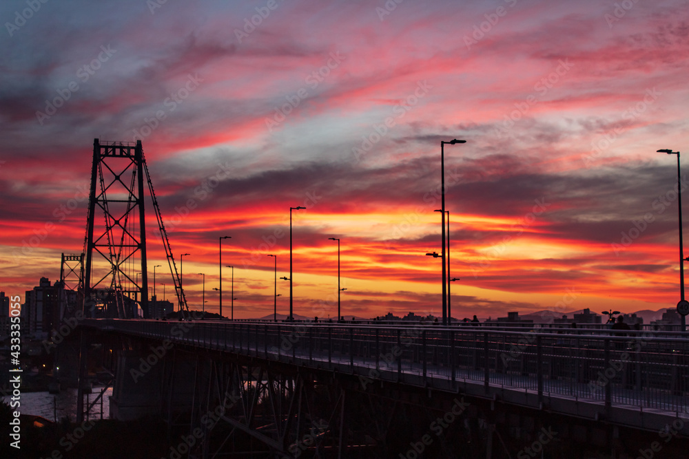 pôr do sol vermelho na Ilha de Florianópolis e a silhueta da Ponte Hercílio Luz em Santa Catarina, Brasil, florianopolis