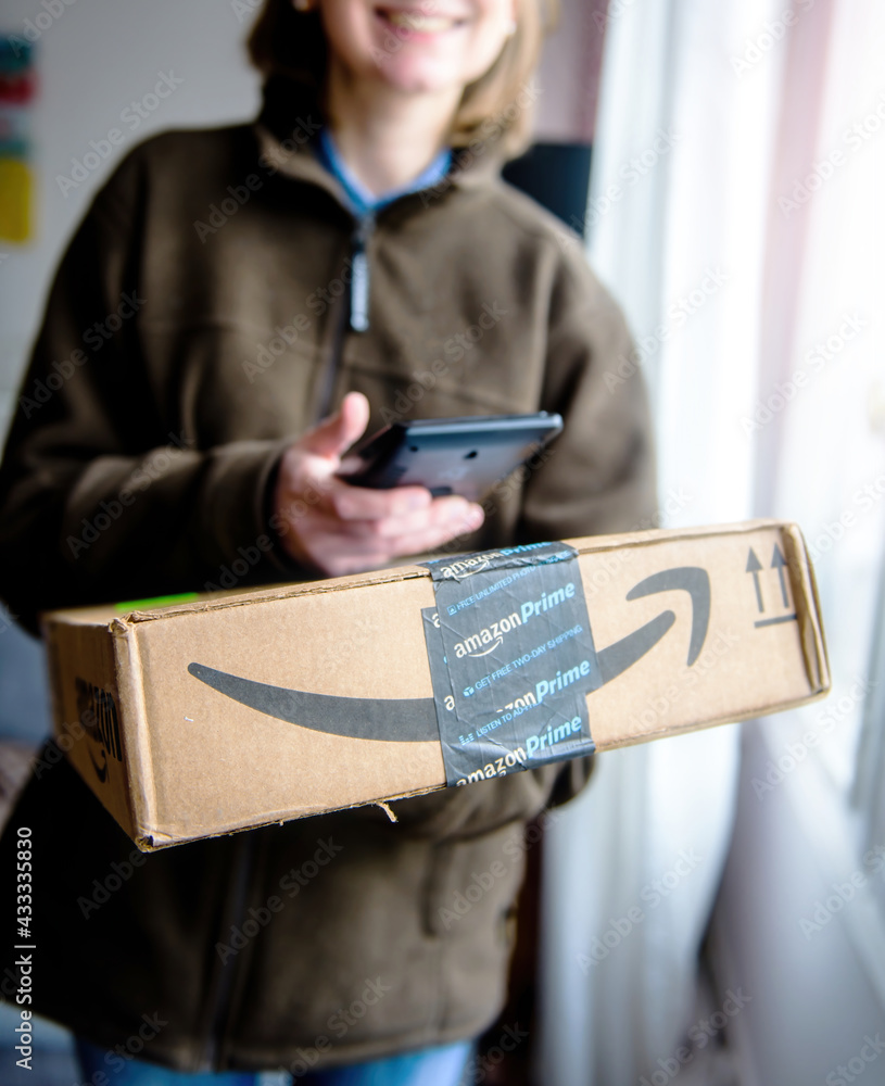 Paris, France - Jan 27, 2016: Smiling UPS female delivery courier employee  scanning with the barcode scanner device the cardboard parcel from Amazon  Prime delivery one day time parcel shipment – Stock-Foto | Adobe Stock