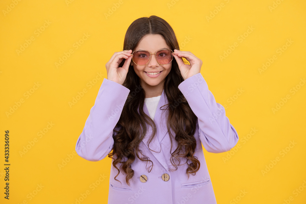 beautiful happy child in stylish purple jacket and sunglasses on yellow background, fashionista. beautiful happy child in stylish purple jacket and sunglasses on yellow background, fashionista.