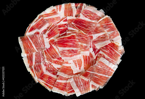 Plato de jamón  de cerdo ibérico de pata negra de bellota. Carne de cerdo curada roja con vetas de tocino blanco. photo