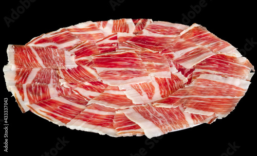 Plato de jamón  de cerdo ibérico de pata negra de bellota. Carne de cerdo curada roja con vetas de tocino blanco.