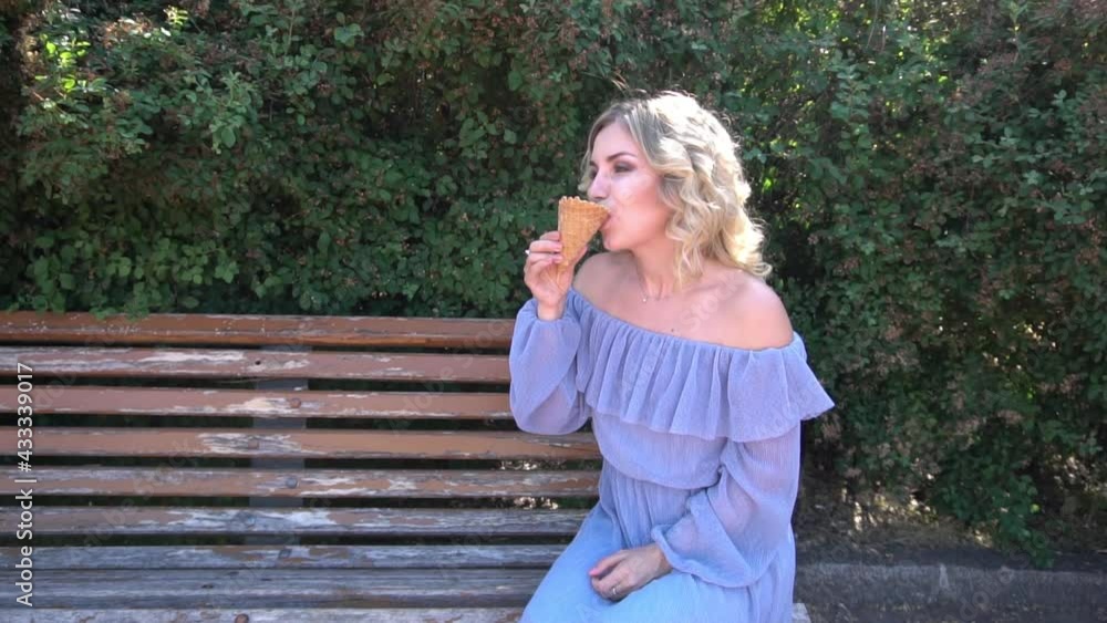 Slow Motion:Young beautiful girl eats ice cream while sitting at street in Europe.Travel concept Slow Motion:Young beautiful girl eats ice cream while sitting at street in Europe.Travel concept