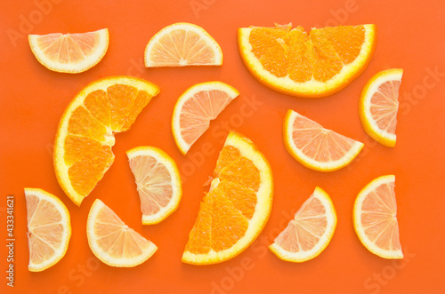 Pattern of lemon and orange slice on orange background. Fruit summer concept.