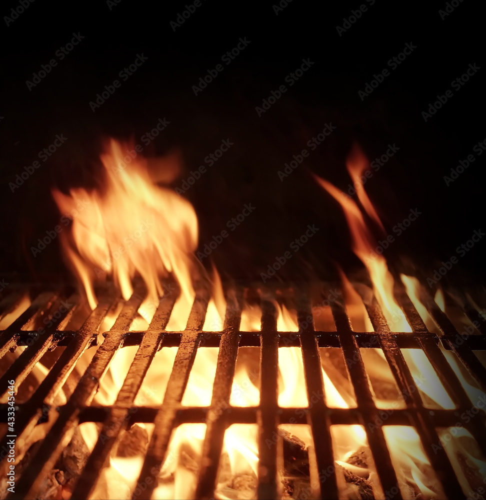 Barbecue Fire Grill Isolated On Black Background. BBQ Flaming Grill Background Isolated. Hot Barbeque Charcoal Cast Iron Grill With Bright Flames.