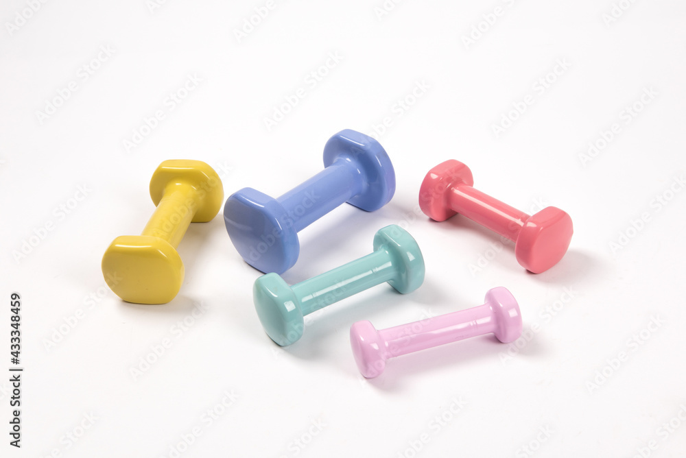 Set of different colorful fitness dumbbells on white background Set of different colorful fitness dumbbells on white background