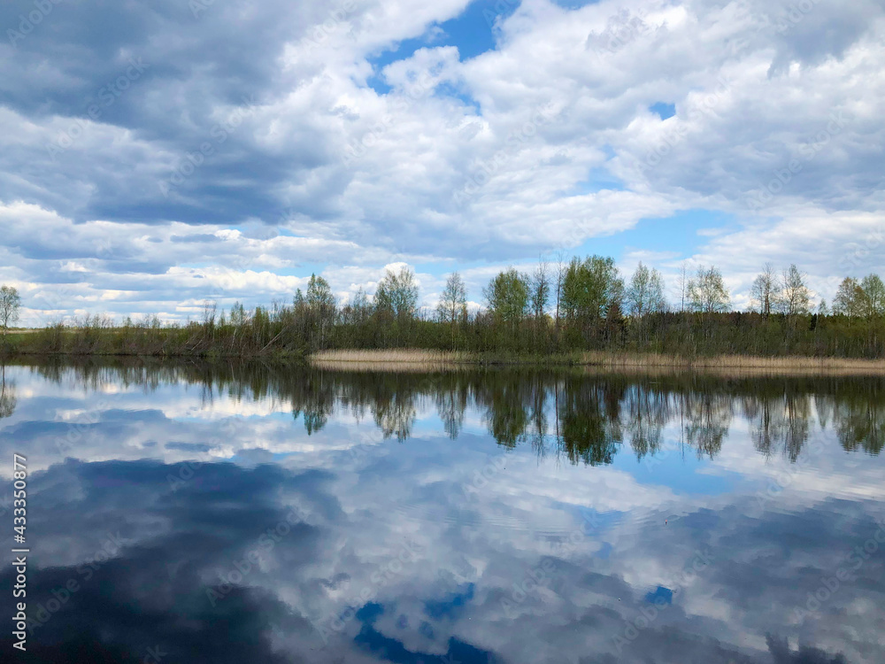 Reflection of clouds in the lake and the island in the distance, full of calm.