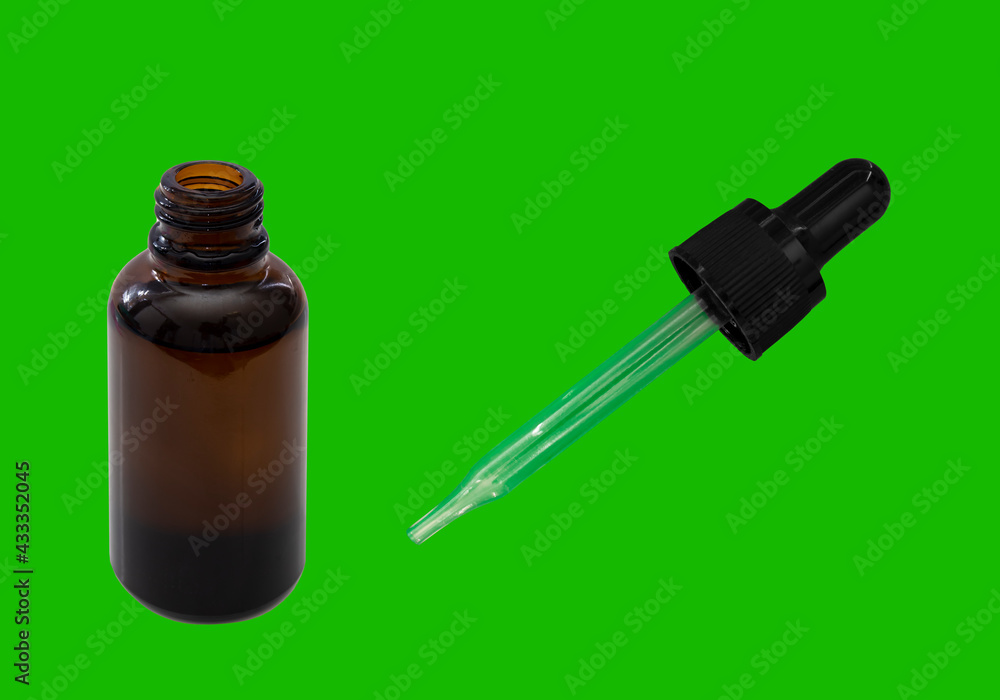 An open cannabis oil amber bottle on a green table. Chroma key An open cannabis oil amber bottle on a green table. Chroma key