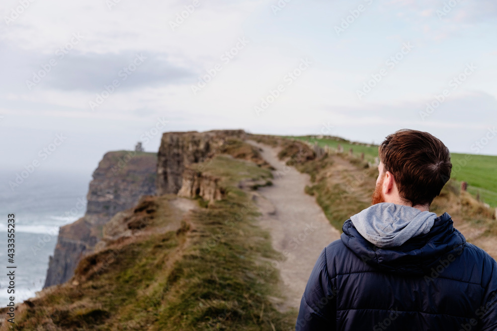 Mid adult man on The Cliffs of Moher, The Burren, County Clare, Ireland Mid adult man on The Cliffs of Moher, The Burren, County Clare, Ireland
