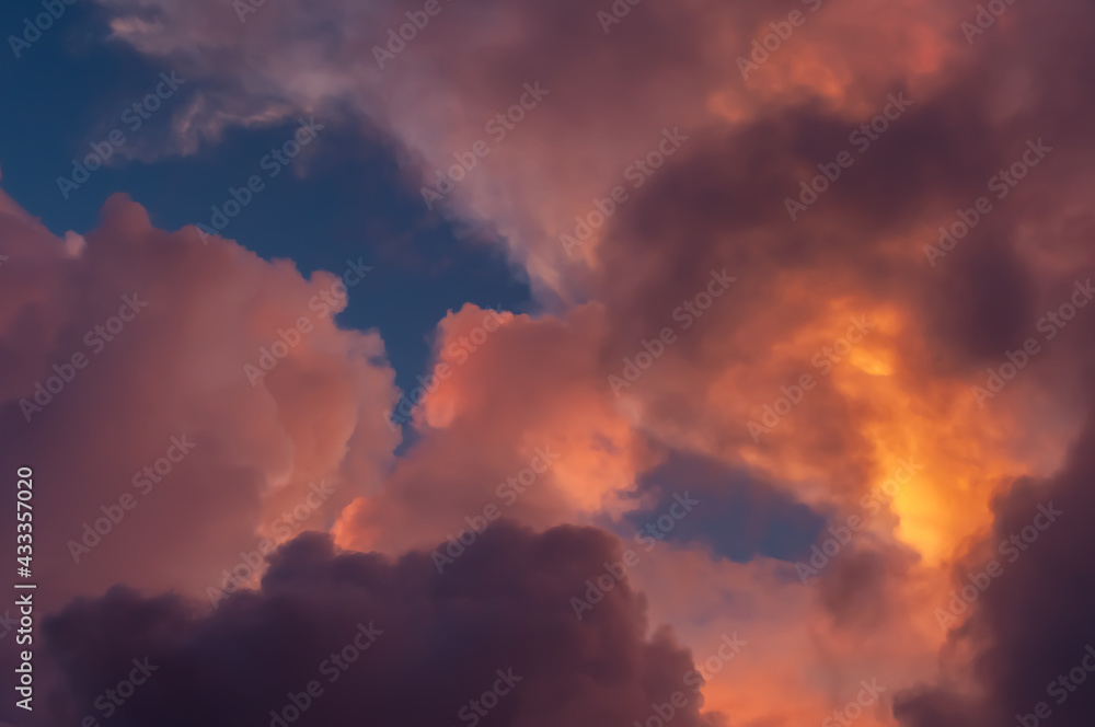  Amazing clouds formation yellow, orange and pink illuminated by a magic sunlight contrasting with the blue sky. Cumulonimbus.