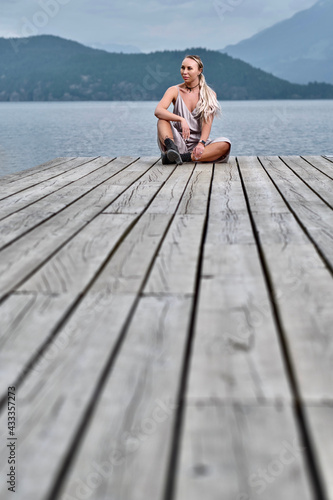 Pretty woman on pier by water. Harrison Hot Springs village by Harrison lake. British Columbia. Canada 