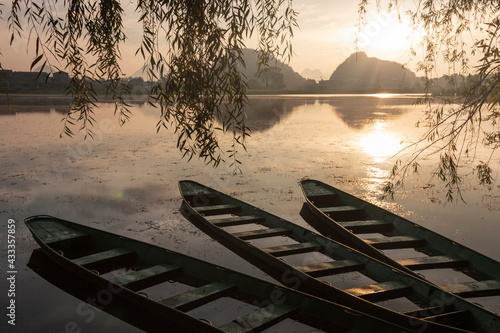 Wooden boats at sunrise in Puzhehei - Yunnan, China photo