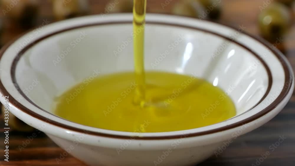 Pouring olive oil onto a small bowl Pouring olive oil onto a small bowl