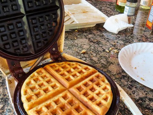 Golden brown waffle ready to come out of the waffle iron and become breakfast