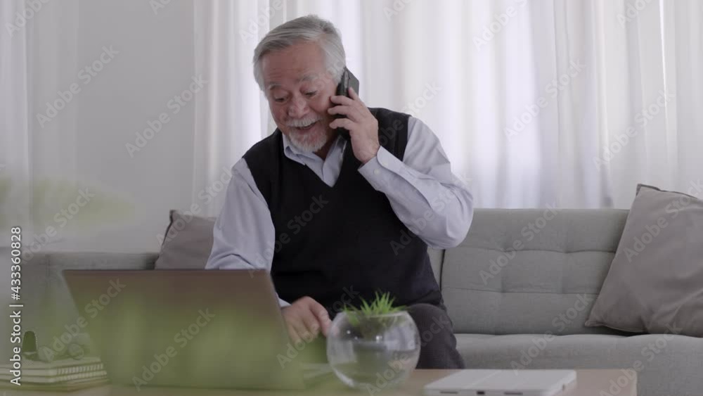 Asian Elderly man play smartphone and labtop in room. Asian Elderly man play smartphone and labtop in room.