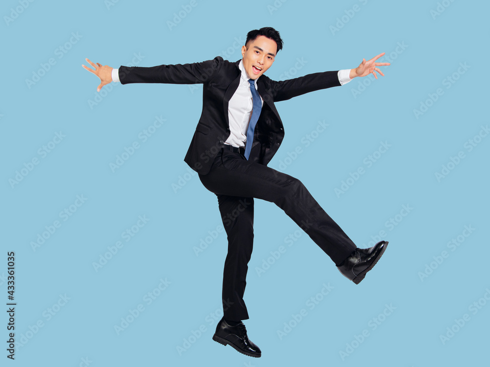 Excited young  businessman jumping and dancing