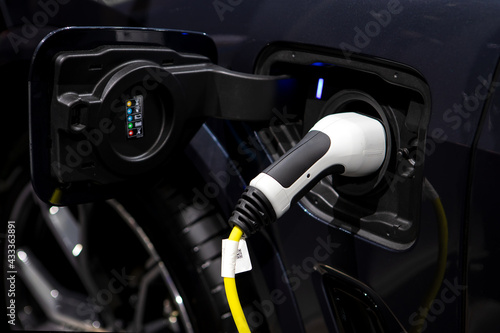 Charging cable plugged into the side of electric car, Car or Electric vehicle, Eco-friendly sustainable energy concept.