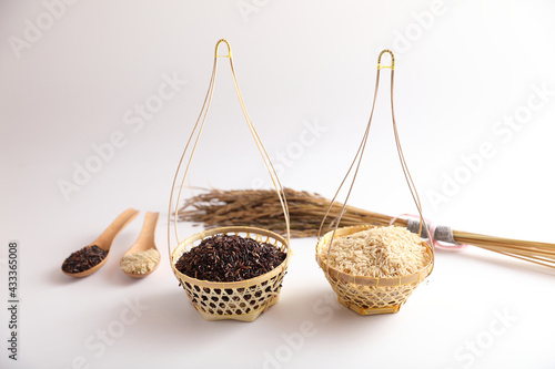 Organic raw brown rice and riceberry rice on wood basket in close up