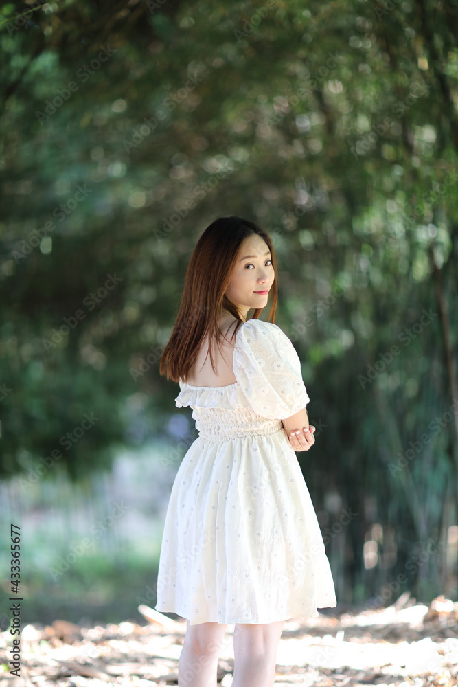Beautiful young woman with white dress on bamboo forest background Beautiful young woman with white dress on bamboo forest background