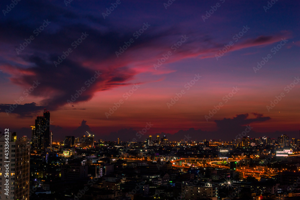 The high angle background of the city view with the secret light of the evening, blurring of night lights, showing the distribution of condominiums, dense homes in the capital community