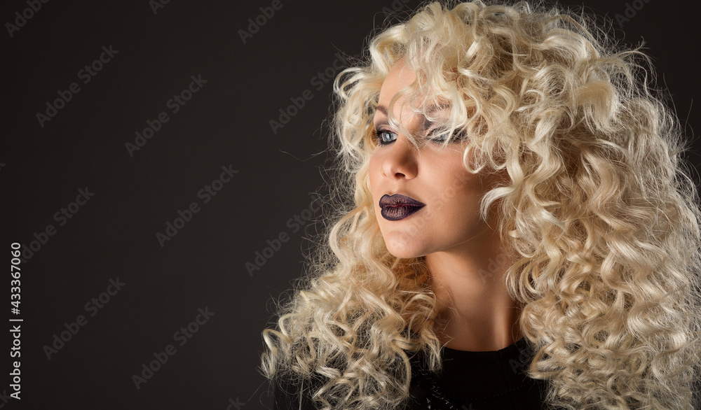 Curly Hair Beauty Woman. Blonde Model with Wavy Hairstyle Curls. Fashion Make up Face. Glamour Girl Portrait over Black Studio Portrait