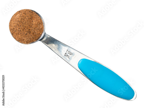 nutmeg powder in measuring teaspoon cutout photo