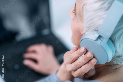 Hearing test or audiogram. Senior woman self-testing hearing ability with laptop