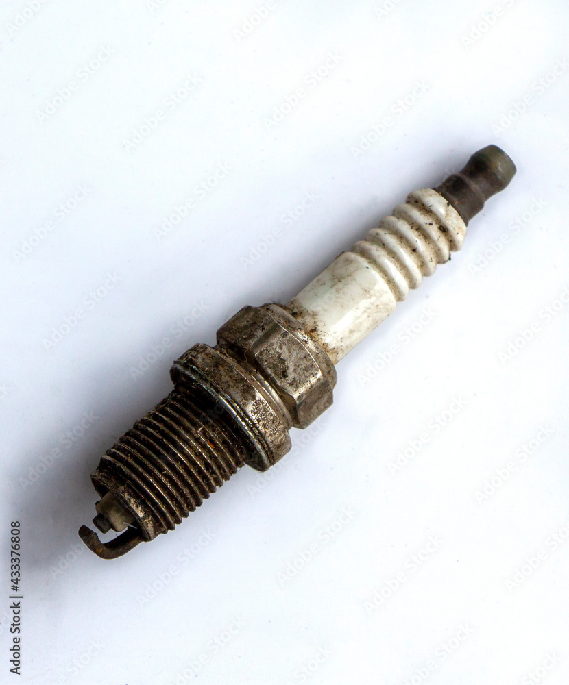 old used spark plug on white background. Broken auto part in a garage old used spark plug on white background. Broken auto part in a garage