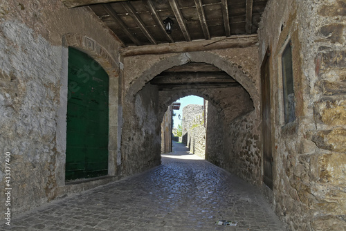 A street between old medieval stone buildings of Bassiano  historic town in Lazio region  Italy.