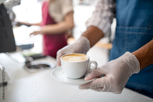 Obscured waiter serving coffee in cafe  small business  coronavirus and new normal concept.