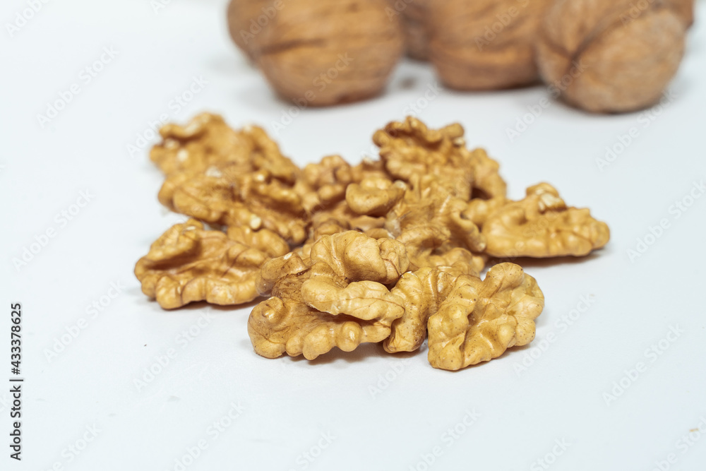 walnut kernels and whole nuts on a light background. shallow depth of field walnut kernels and whole nuts on a light background. shallow depth of field