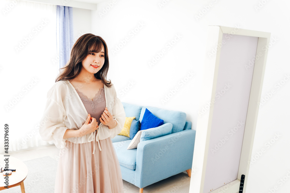 自宅で服を着替える若い女性 自宅で服を着替える若い女性