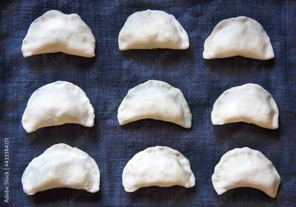 Raw dumplings with potatoes on towel