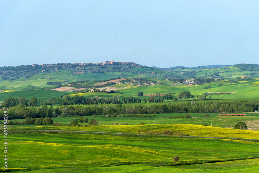 Amazing spring view of medieval small town with cypress trees and colorful spring flowers in Tuscany, Italy. Typical Tuscany scenic landscape.