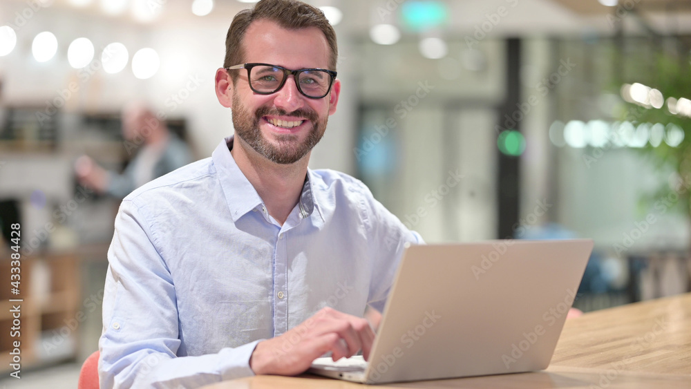 Businessman with Laptop Smiling at Camera in Office Businessman with Laptop Smiling at Camera in Office