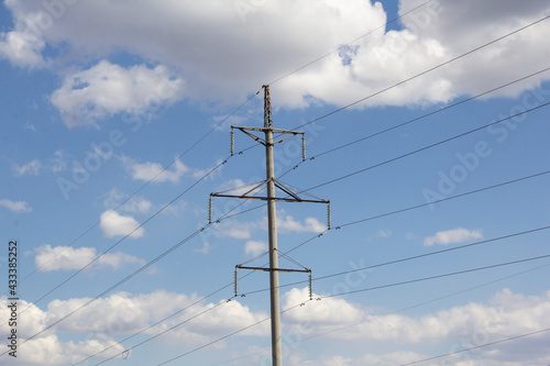 Power lines run through the spring fields. Supports stand in a rural landscape