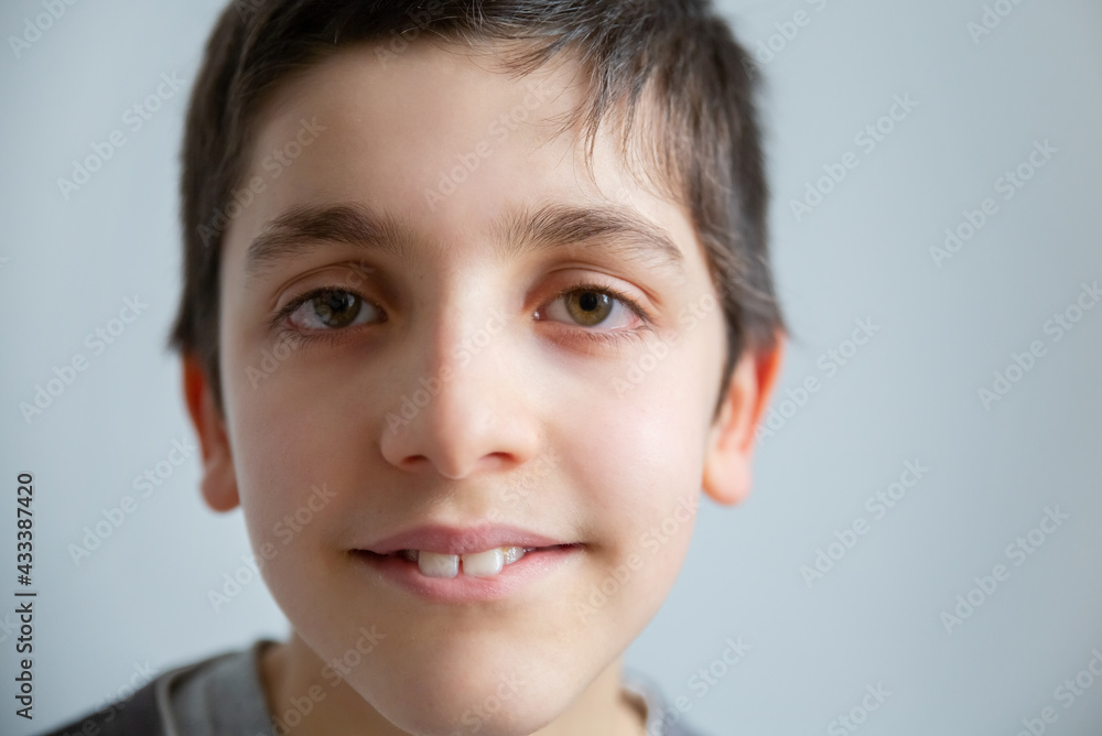 Close-up of brunette boy looking at camera. Isolated portrait of smiling Caucasian teenager on white background. Close-up of boy concept Close-up of brunette boy looking at camera. Isolated portrait of smiling Caucasian teenager on white background. Close-up of boy concept