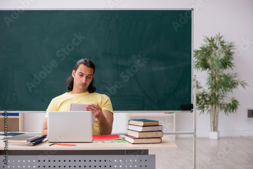 Young male student preparing for exams in the classroom