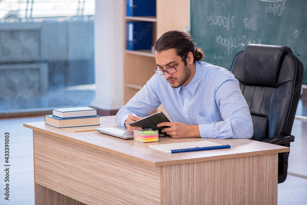 Young male teacher in the classroom Young male teacher in the classroom