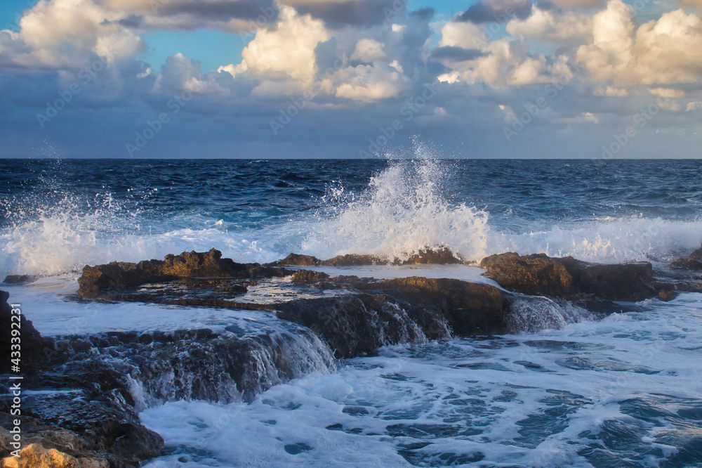 Water splashing and running over rocks in the ocean at Qawra, Malta on a fall evening.