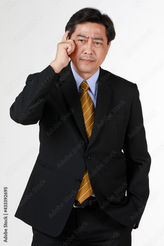 Senior businessman standing thinking about problem. His face seems worried as his finger touching his head likes very thoughtful. Senior businessman standing thinking about problem. His face seems worried as his finger touching his head likes very thoughtful.